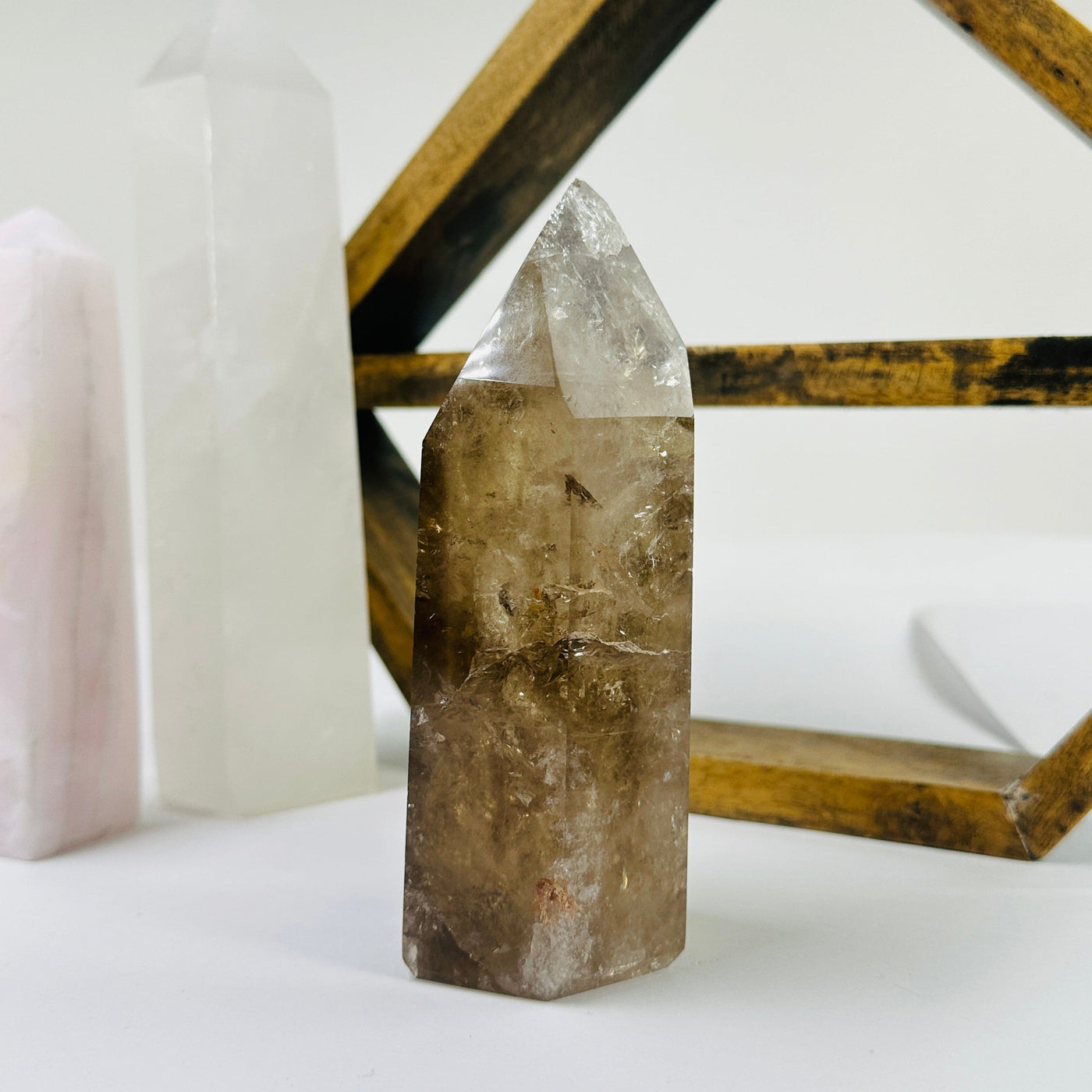 smokey quartz point with decorations in the background