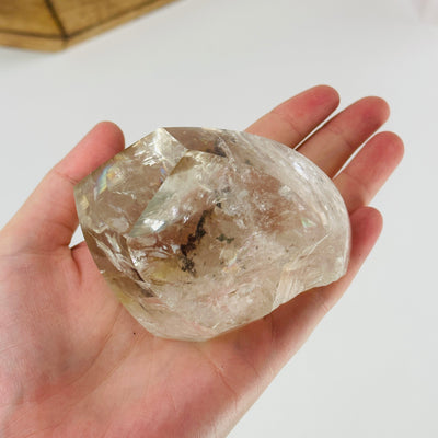 hand holding up polished crystal quartz