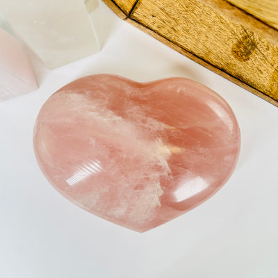 rose quartz heart with decorations in  the background