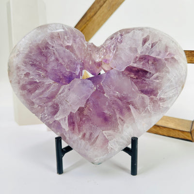 amethyst heart with stand with decorations in the background