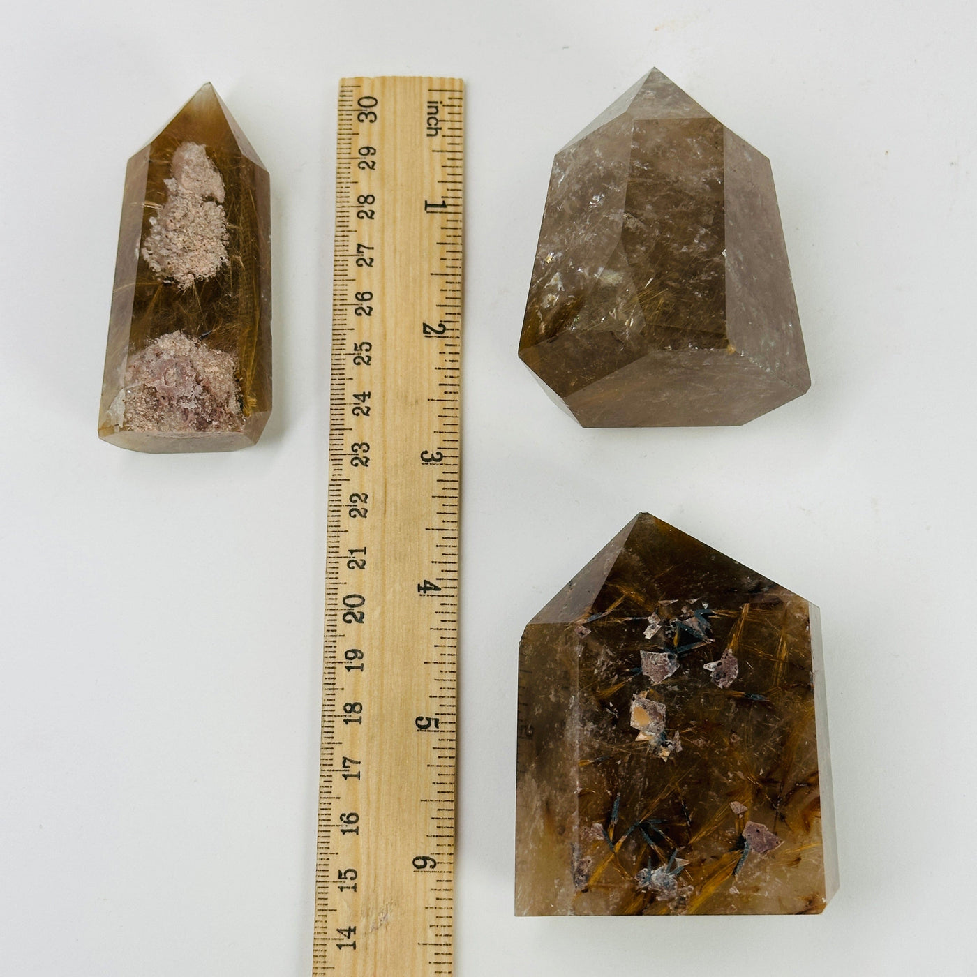 rutilated quartz point next to a ruler for size reference