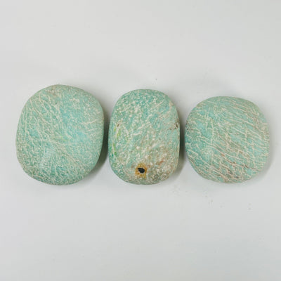 amazonite tumbled stones with decorations in the background