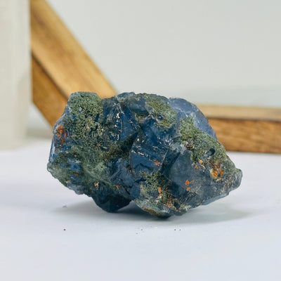 Blue fluorite crystal with decorations in the background