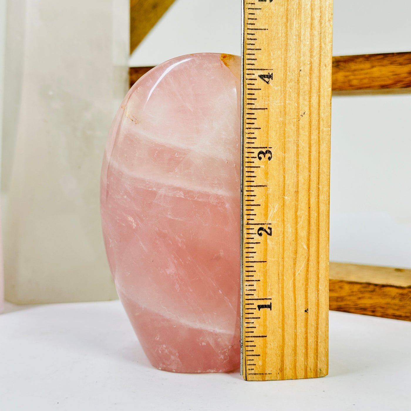 rose quartz cut base next to a ruler for size reference