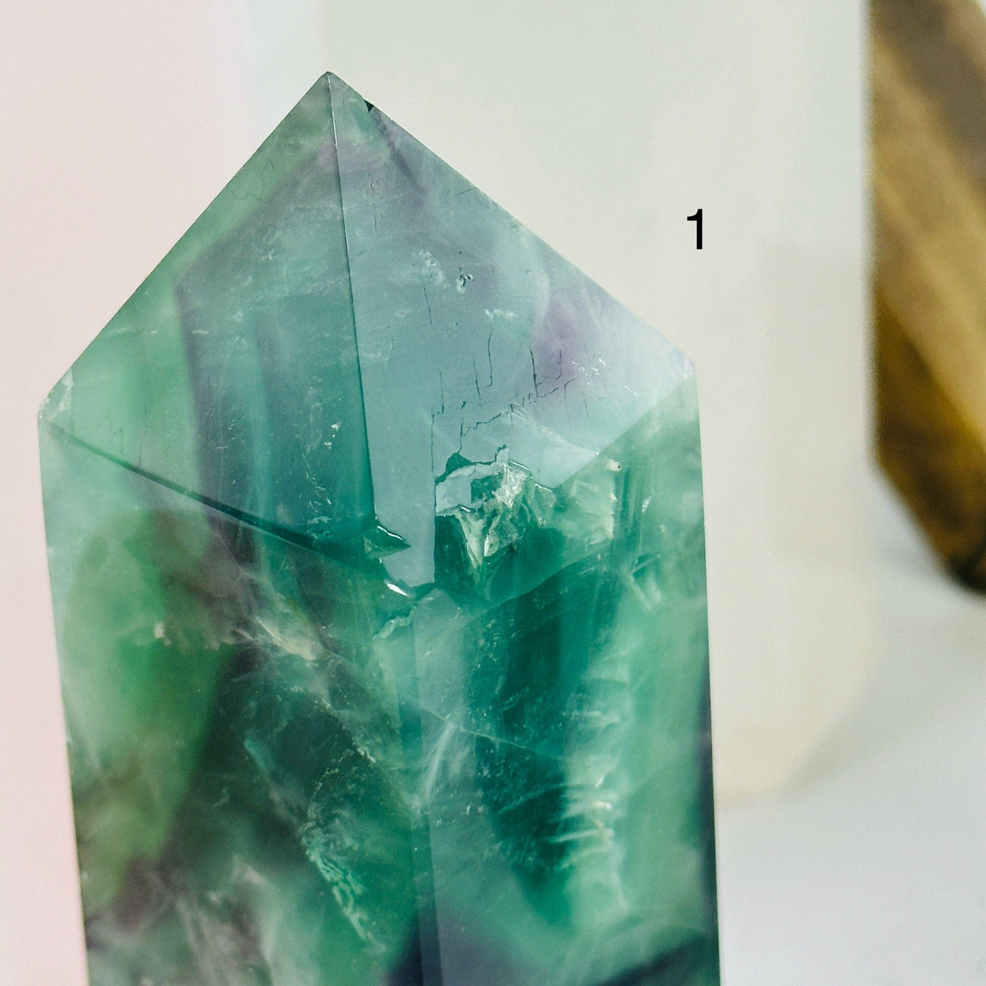 fluorite point with decorations in the background