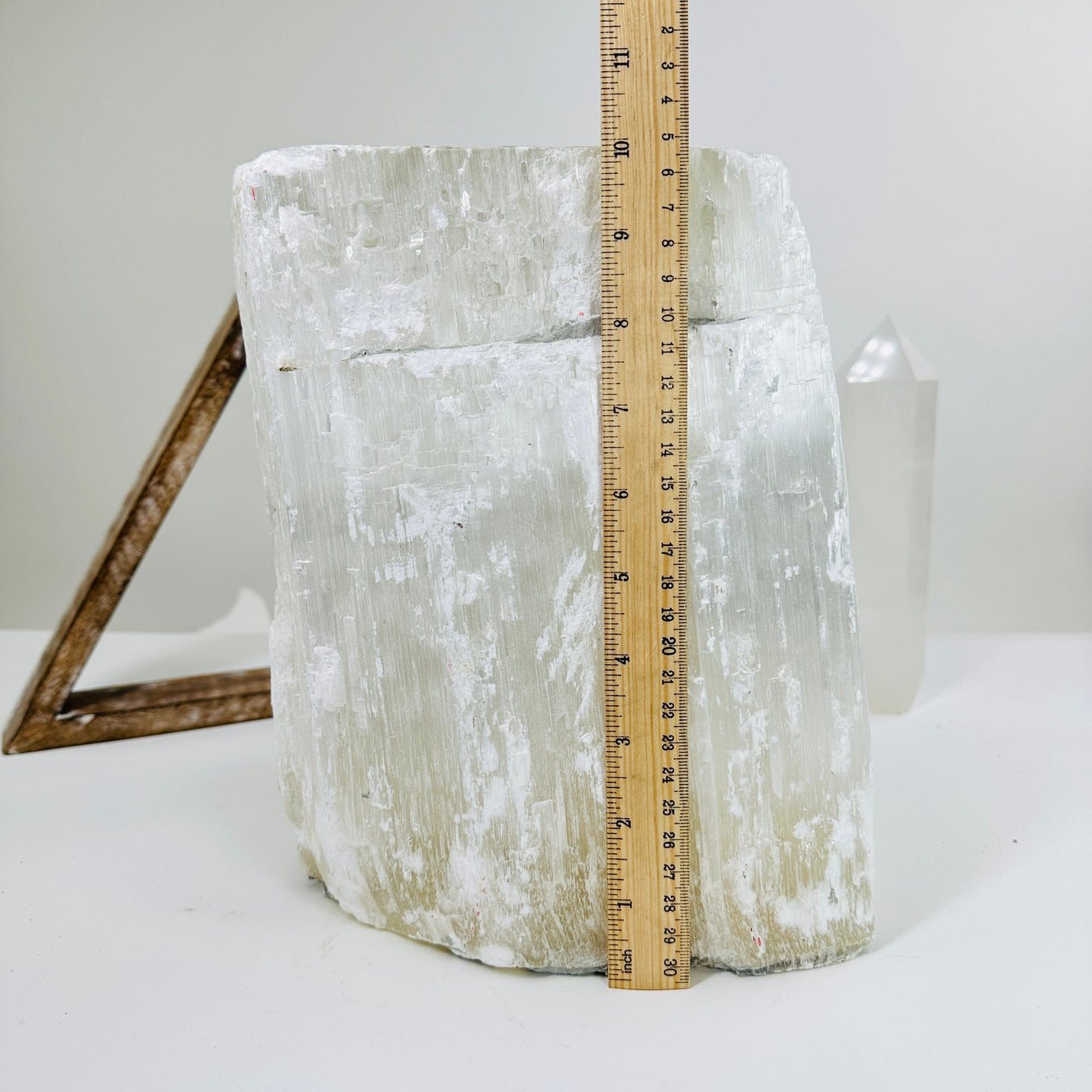 selenite cluster next to a ruler for size reference