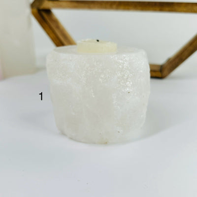 HIMALAYAN SALT CANDLE HOLDER WITH DECORATIONS IN THE BACKGROUND