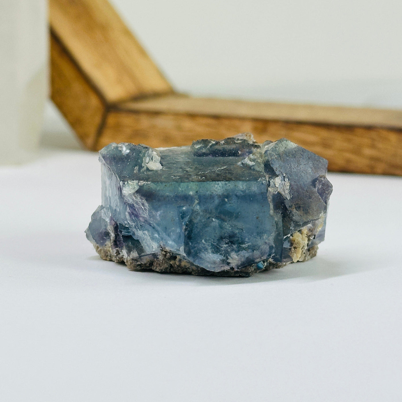 Blue fluorite crystal with decorations in the background