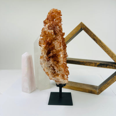 tangerine quartz on stand with decorations in the background