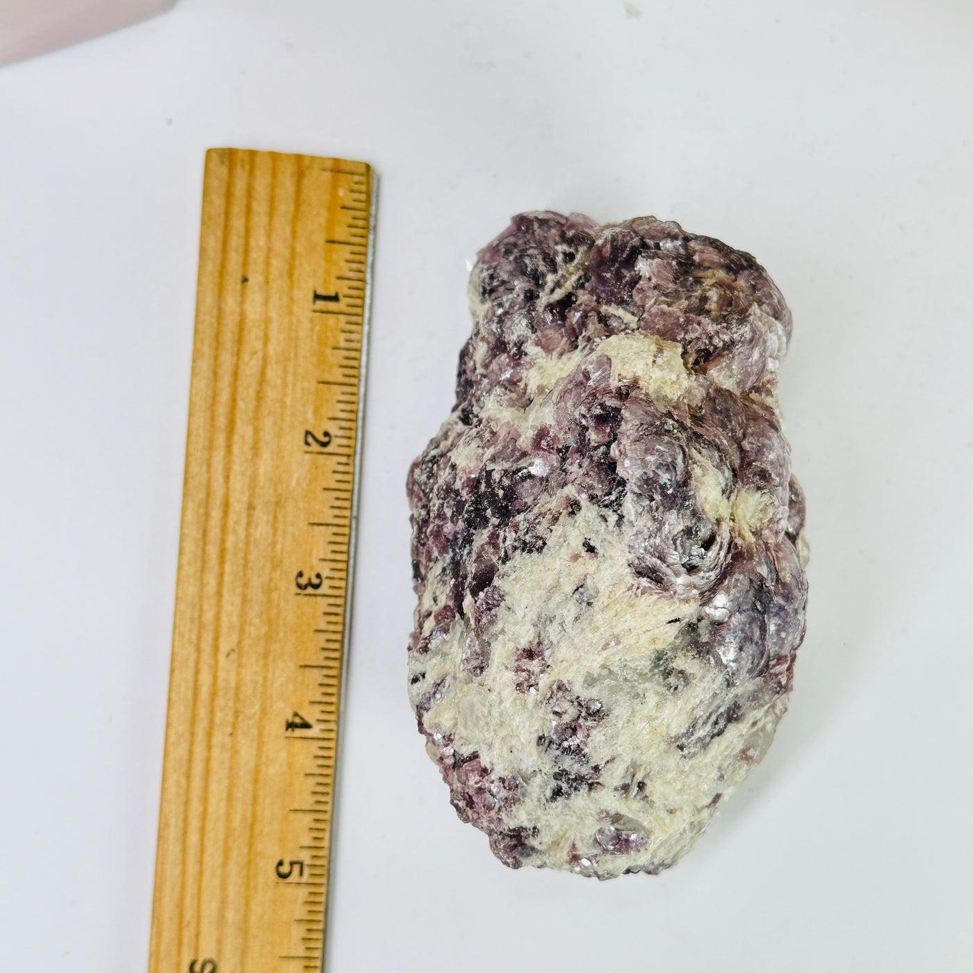 lepidolite next to a ruler for size reference