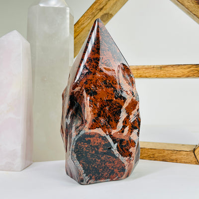 mahogany obsidian point with decorations in the background