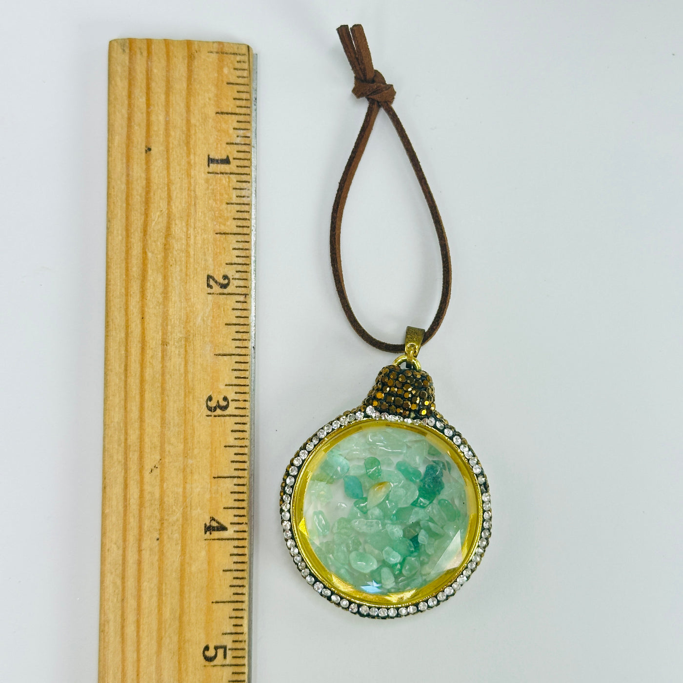 green quartz ornament next to a ruler for size reference