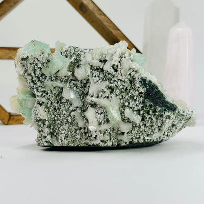green apophyllite with decorations in the background