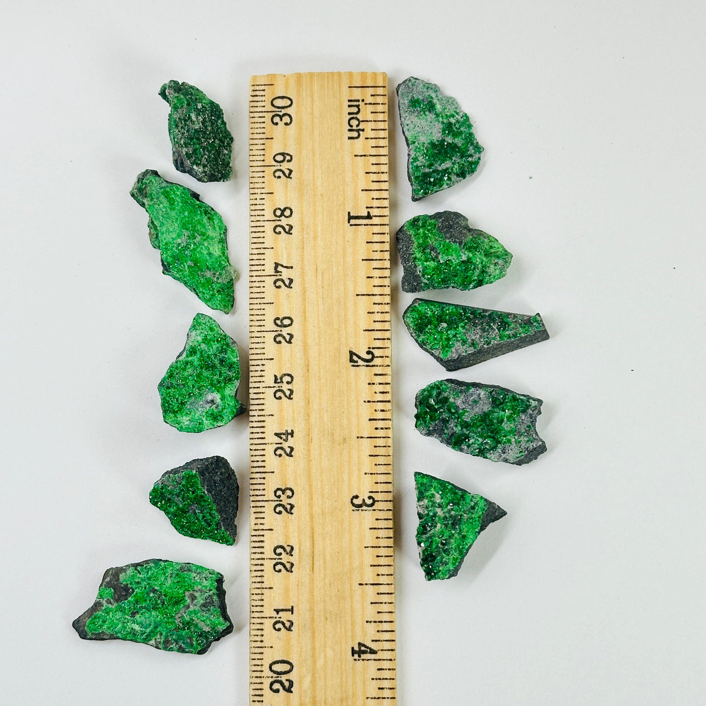 uvarovite pieces next to a ruler for size reference