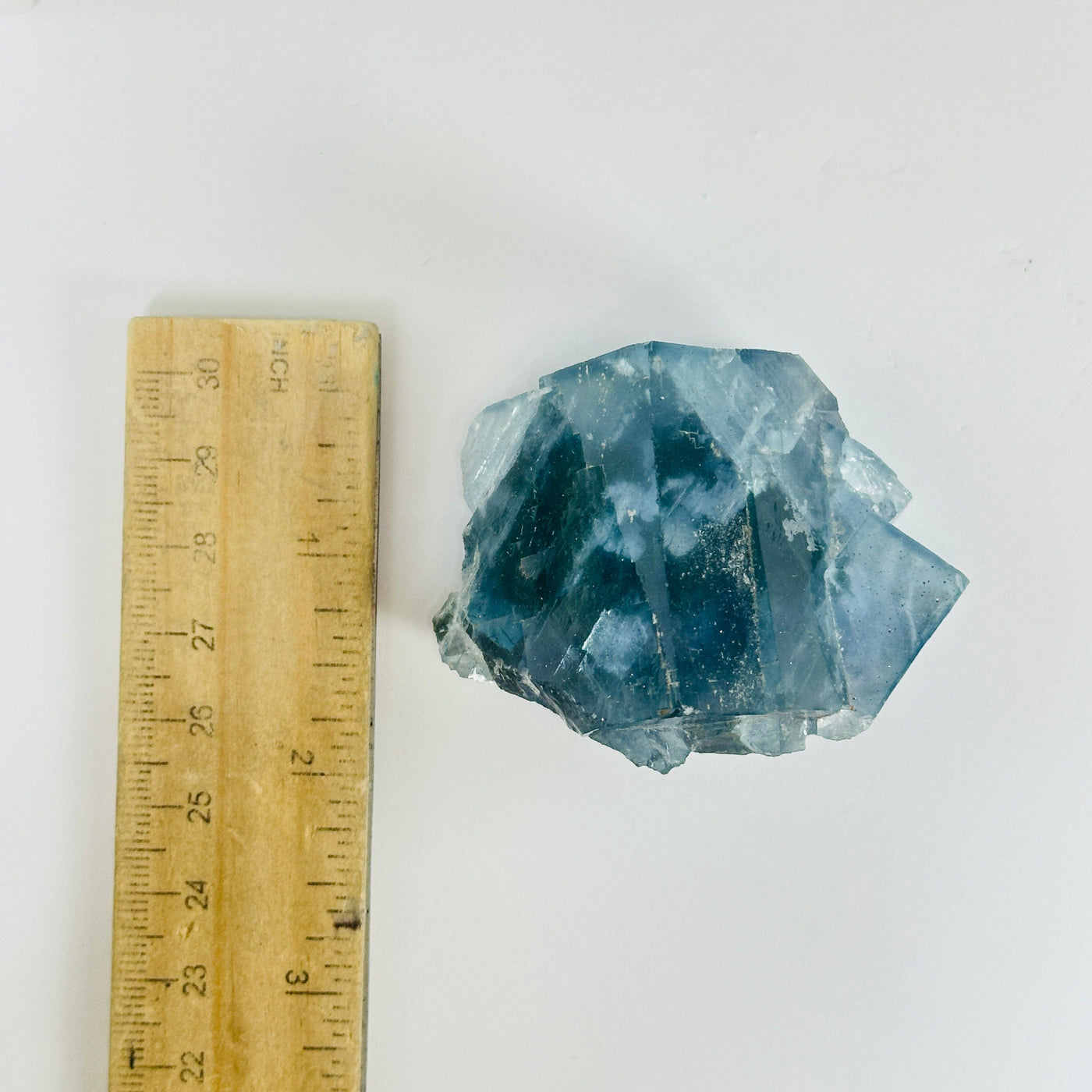 Blue fluorite crystal next to a ruler for size reference