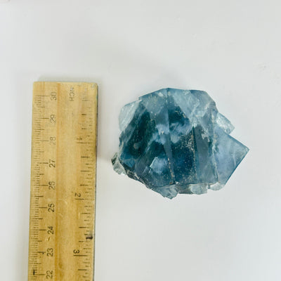 Blue fluorite crystal next to a ruler for size reference