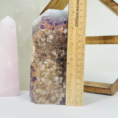 amethyst point next to a ruler for size reference