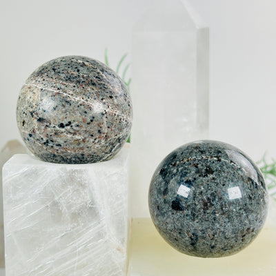 Yooperlite Crystal Sphere - UV Reactive - You Choose both variants in bright lighting with props and plants in the background
