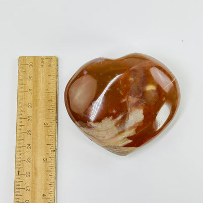 carnelian heart next to a ruler for size reference