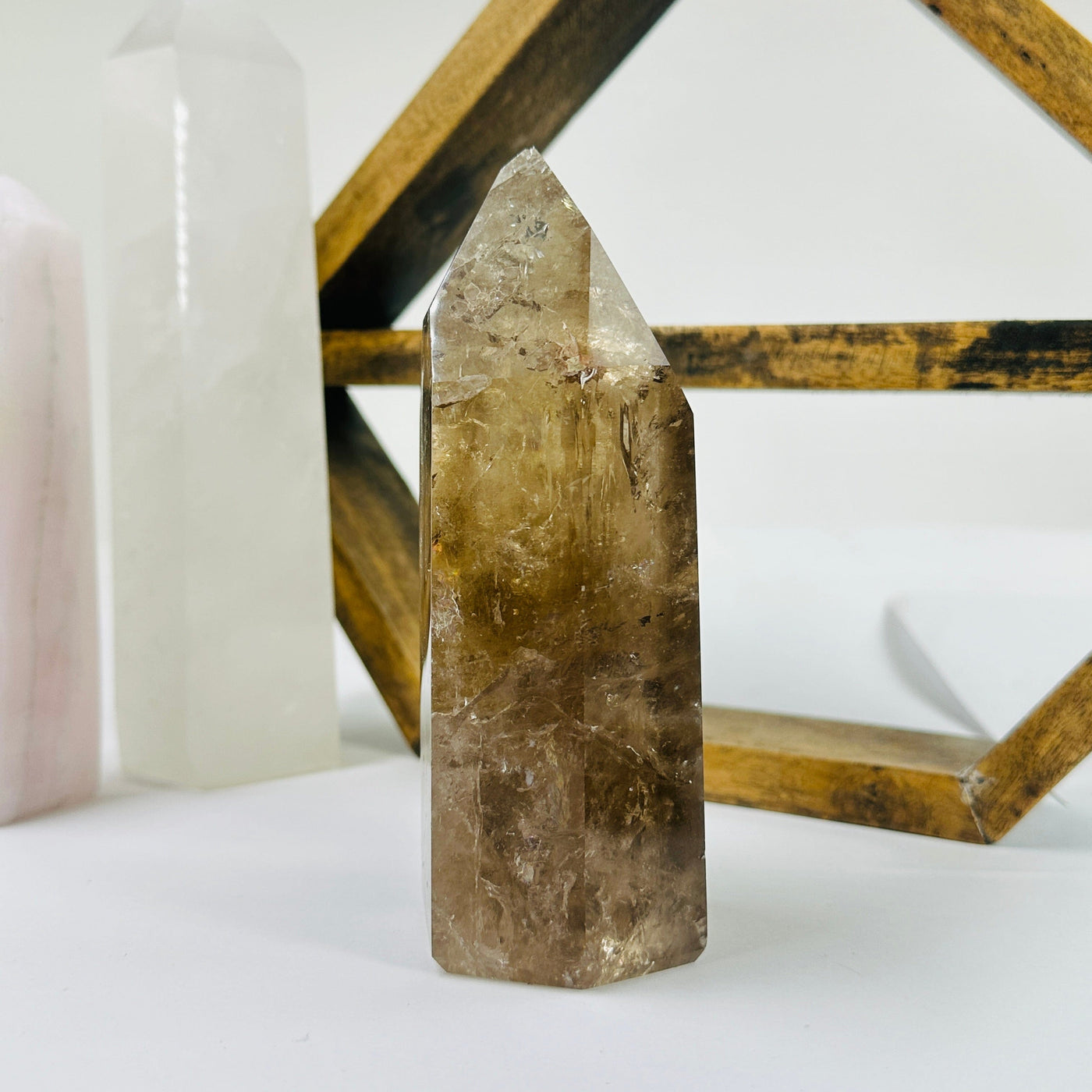 smokey quartz point with decorations in the background