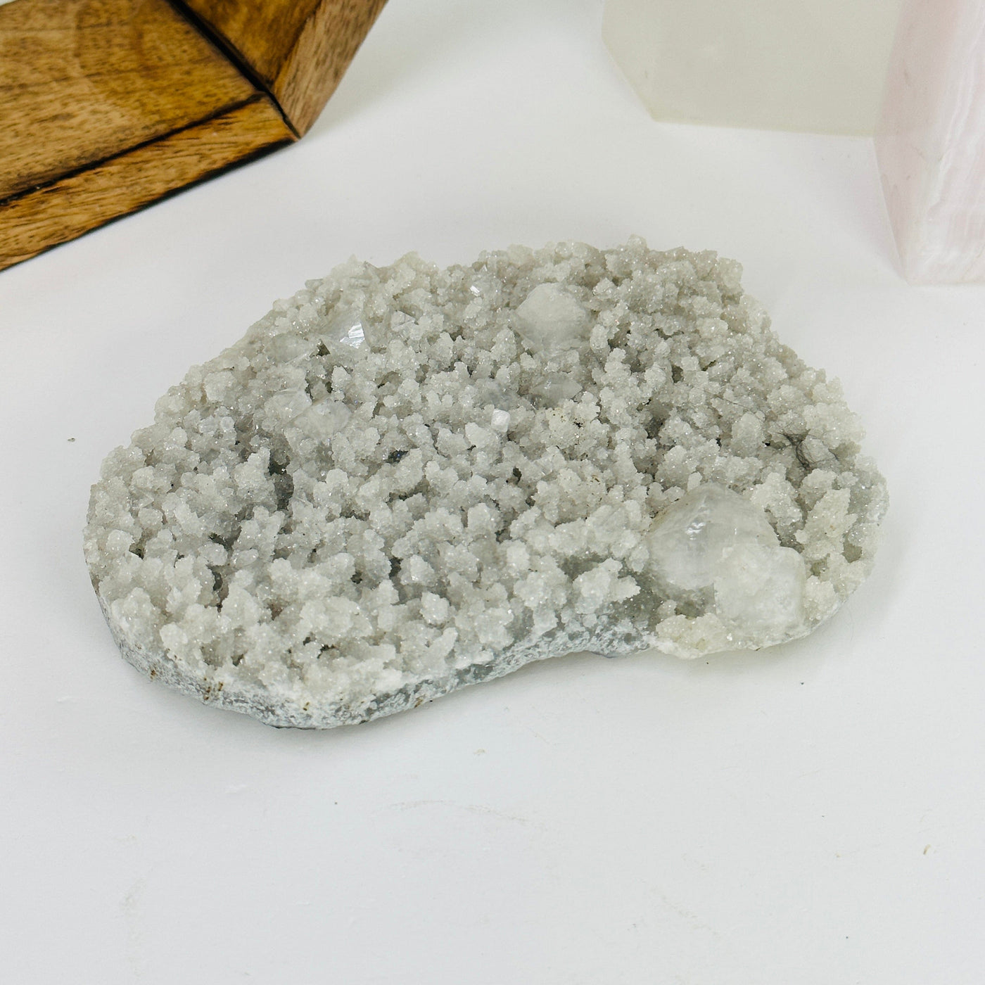 apophyllite slab with decorations in the background