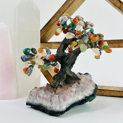 mixed stone tree on amethyst base with decorations in the background