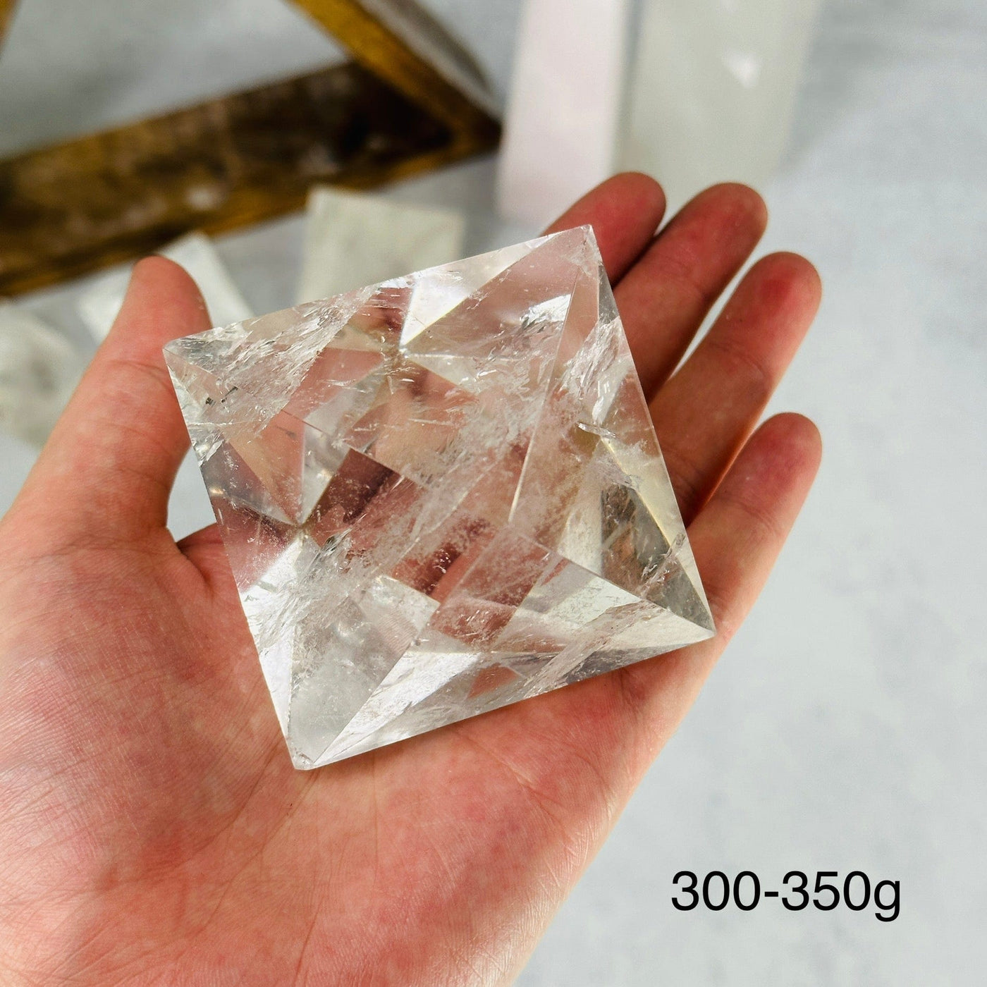 hand holding up 300-350g crystal quartz shape