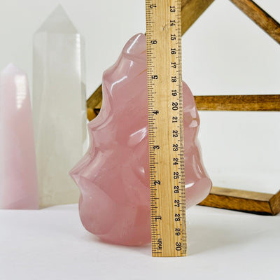 rose quartz flame tower next to a ruler for size reference