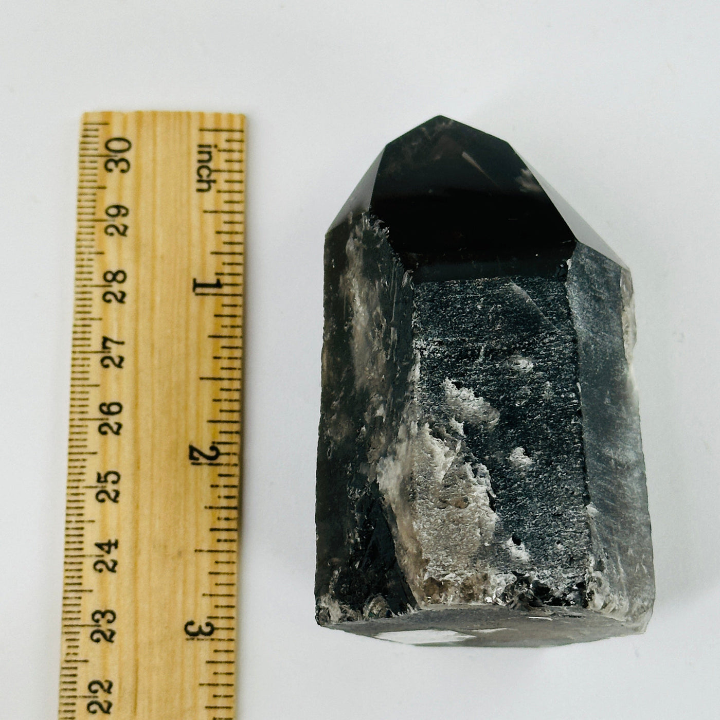 smokey quartz polished point next to a ruler for size reference