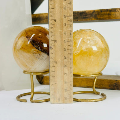 golden healer sphere next to a ruler for size reference