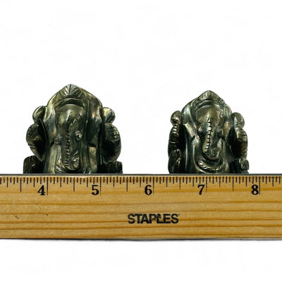 Pyrite Crystal Elephant Ganesha Carvings next to a ruler for size reference.