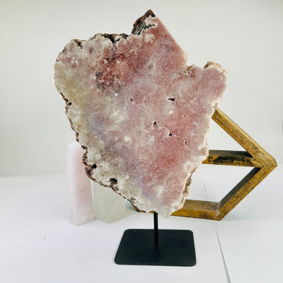 pink amethyst on stand with decorations in the background