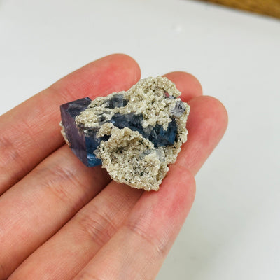 Blue fluorite crystal with decorations in the background