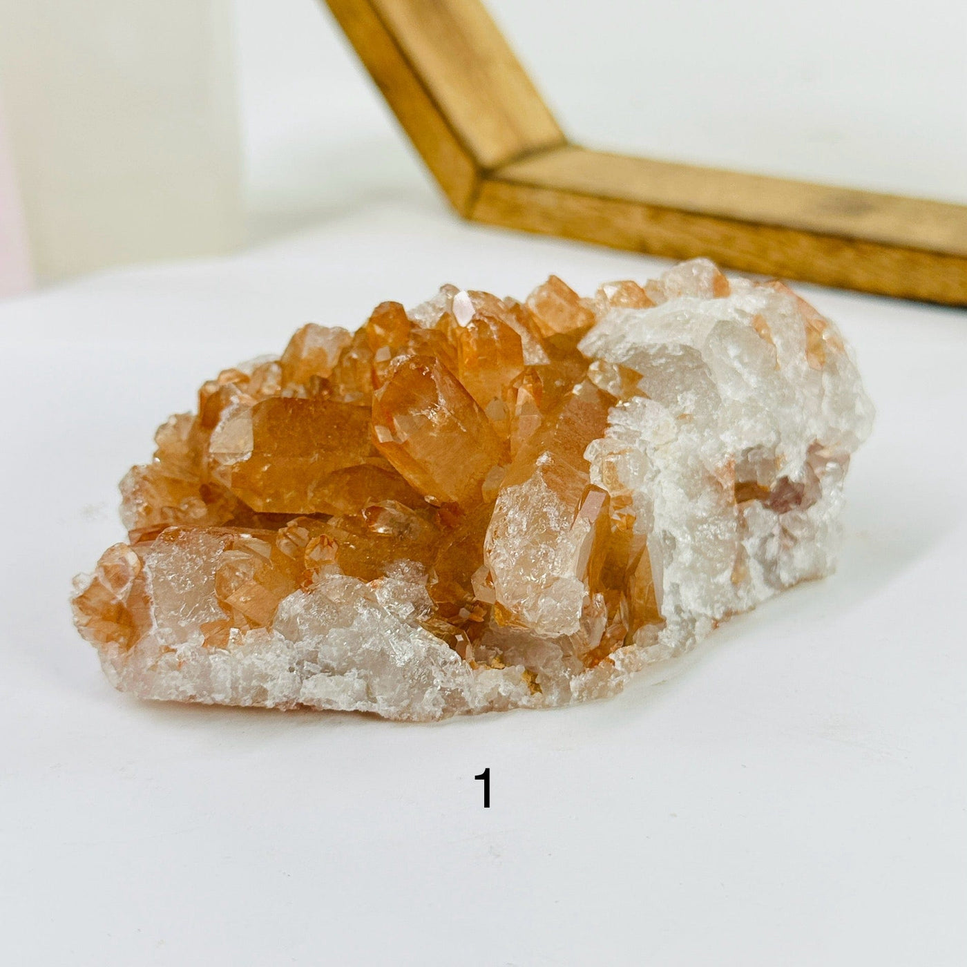 tangerine quartz cluster with decorations in the background