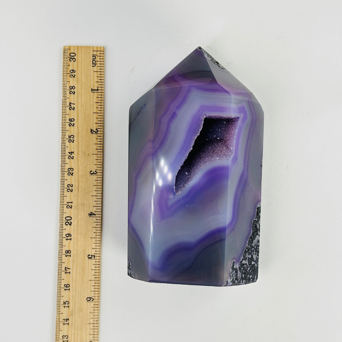 purple dyed agate druzy point next to a ruler for size reference