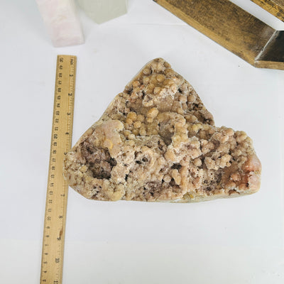 pink amethyst next to a ruler for size reference