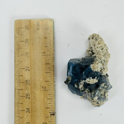 blue fluorite next to a ruler for size reference