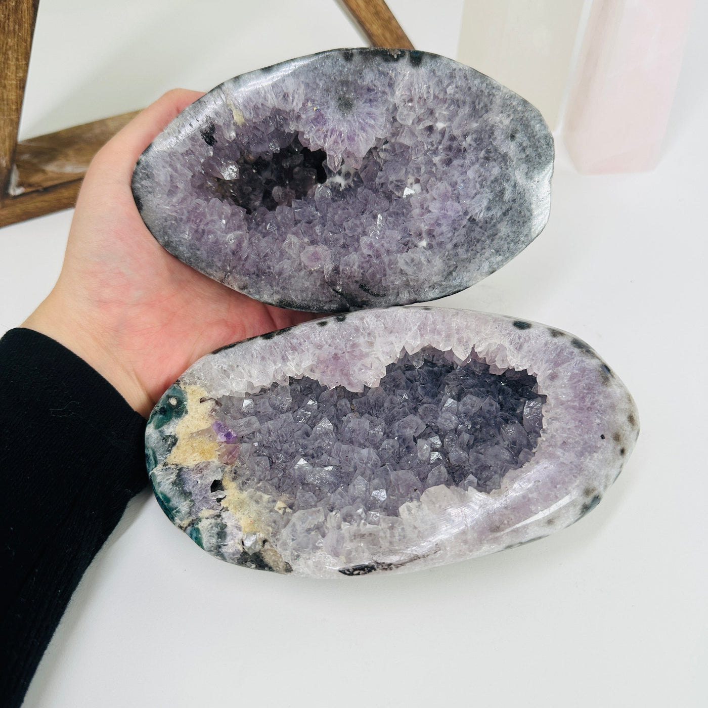 hand holding up amethyst geode box with decorations in the background