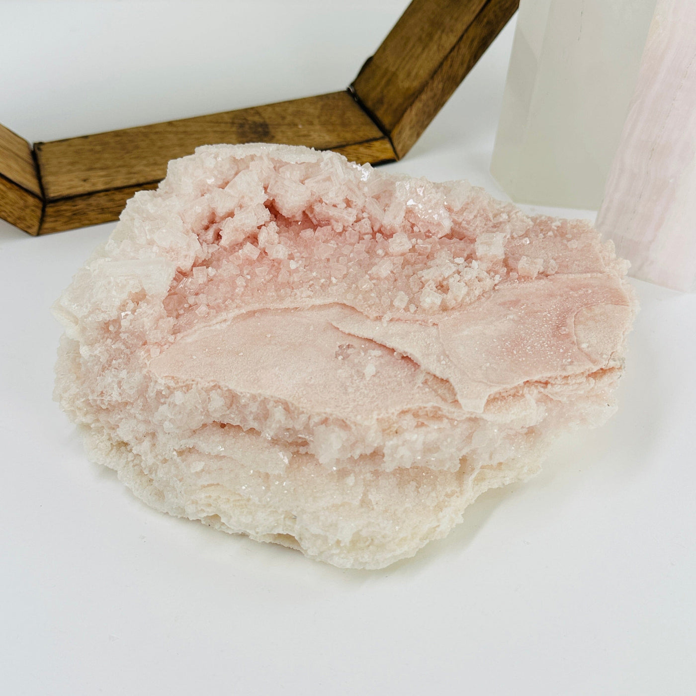 pink halite cluster with decorations in the background