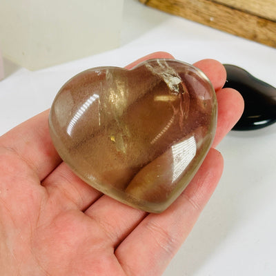 smoky quartz heart with decorations in the background