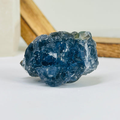 Blue fluorite crystal with decorations in the background