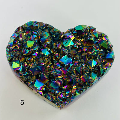 Rainbow titanium heart with decorations in the background
