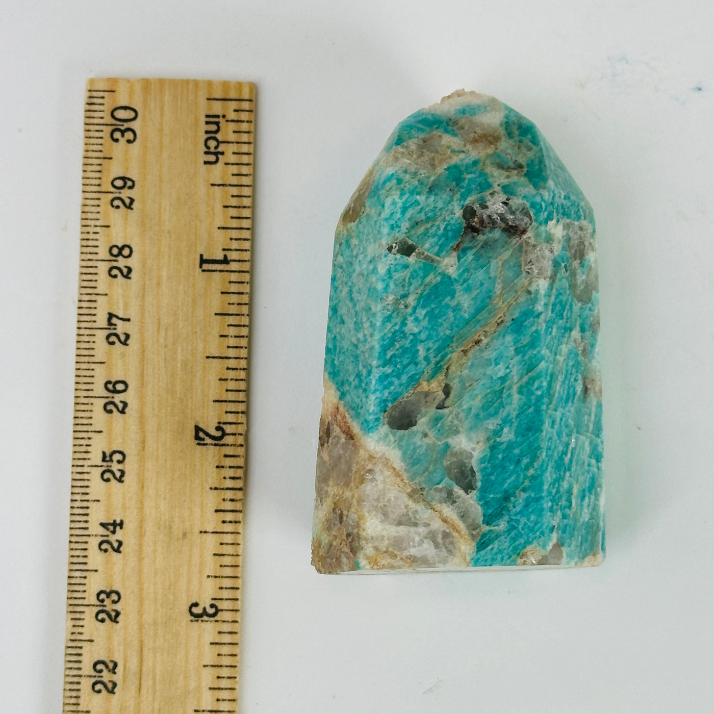 Amazonite polished point next to a ruler for size reference 