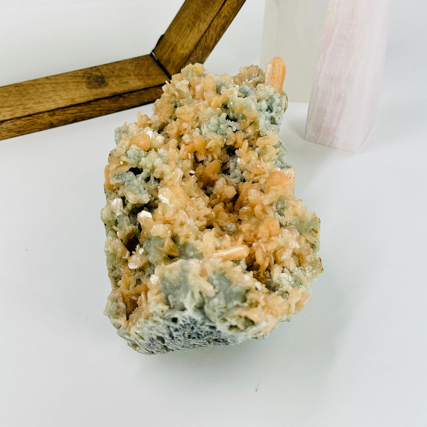 green apophyllite with peach stilbite with decorations in the background