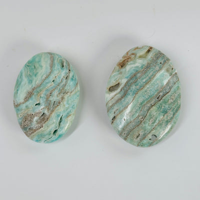 blue aragonite palm stones with decorations in the background