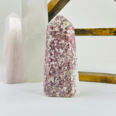 pink tourmaline point with decorations in the background