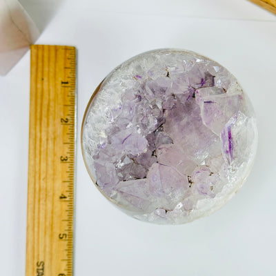 amethyst sphere next to a ruler for size reference