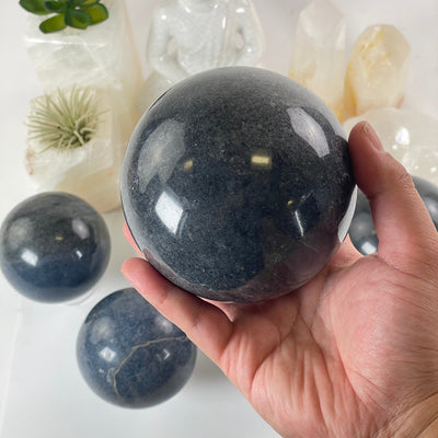 Lazulite Crystal Sphere - You Choose one in hand for size reference with others in the background