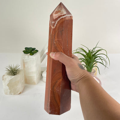 Red Jasper Crystal Obelisk in a hand for size reference