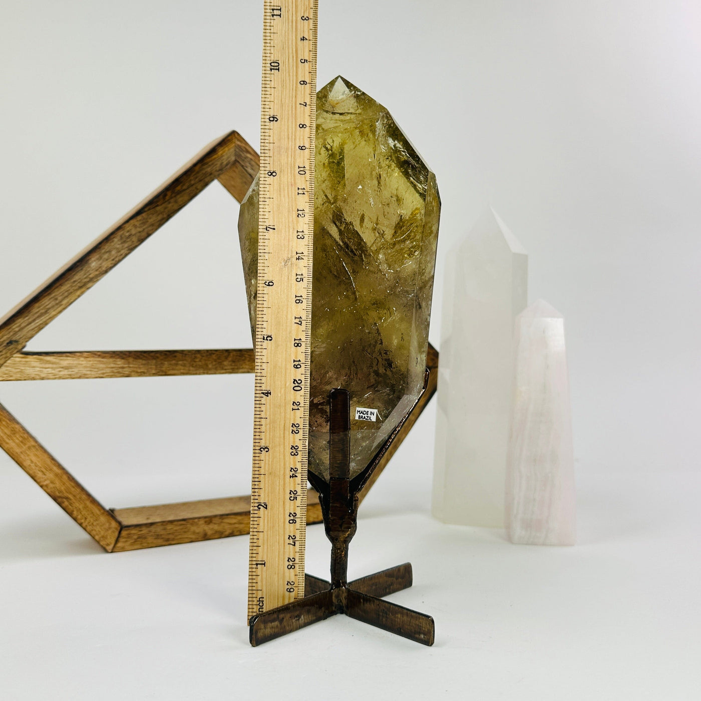 citrine on metal stand next to a ruler for size reference